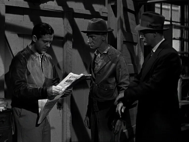 Saboteur (1942) movie still: medium — A dimly lit wooden structure with exposed wall studs and structural framing. Three men in period clothing…