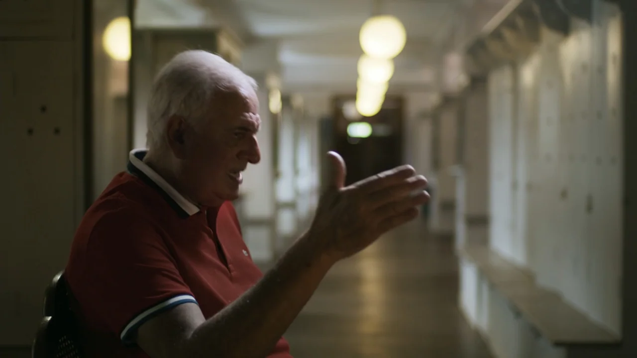 An Affair: A Dangerous Sexual Play (2014) movie still: medium — A locker room with a long row of white metal lockers and overhead globe lights. An…