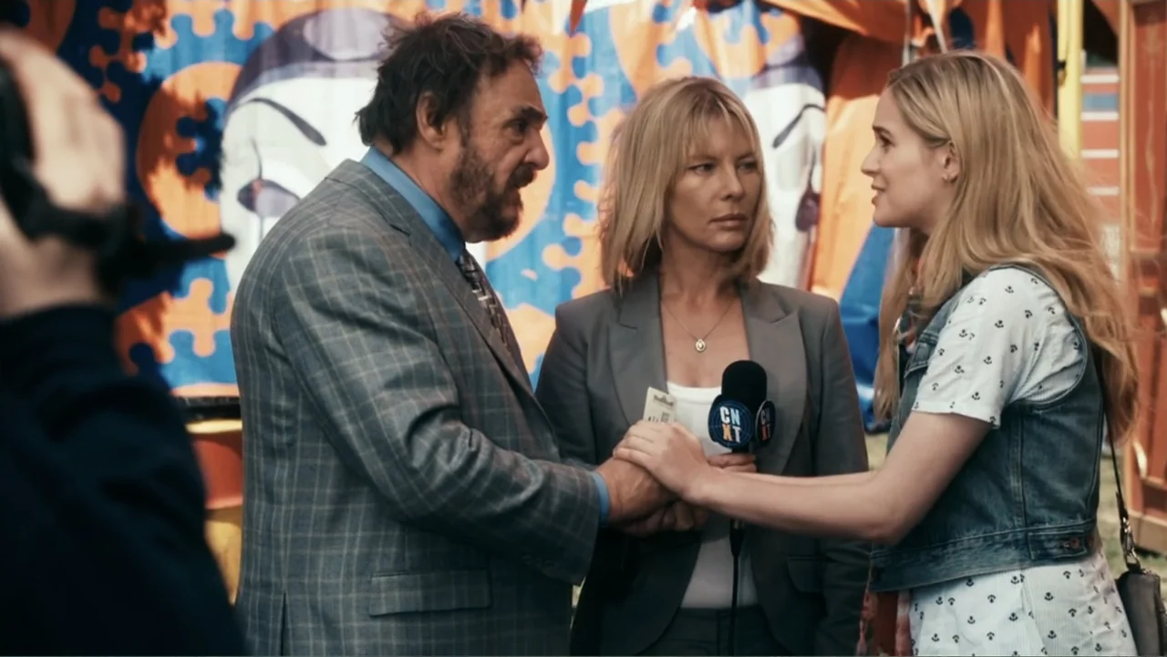 Sophie & Sheba (2010) movie still: medium — An outdoor fairground features a large, colorful tent with a jester pattern backdrop. A young woman…