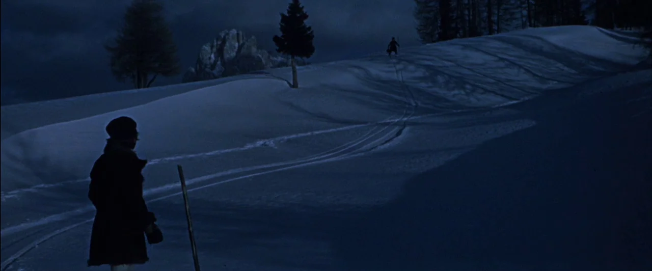 The Fearless Vampire Killers (1967) movie still: wide — A snowy mountain landscape at night features scattered pine trees under a dark sky. A person…