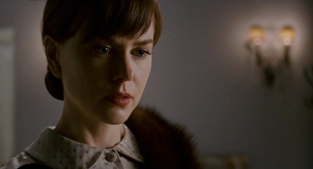 Fur: An Imaginary Portrait Of Diane Arbus (2006) movie still: closeup — An indoor setting with a soft-focus background containing a wall-mounted…