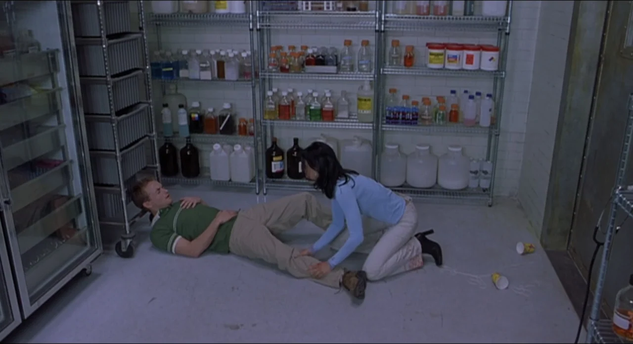 Scary Movie 2 (2001) movie still: fullbody — A laboratory storage room features metal shelving units stocked with colorful chemical bottles and…