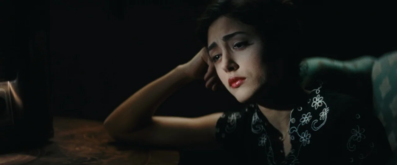 Chicken With Plums (2011) movie still: closeup — A woman sits in a dark room illuminated by a light from the side. She rests her head on her hand…