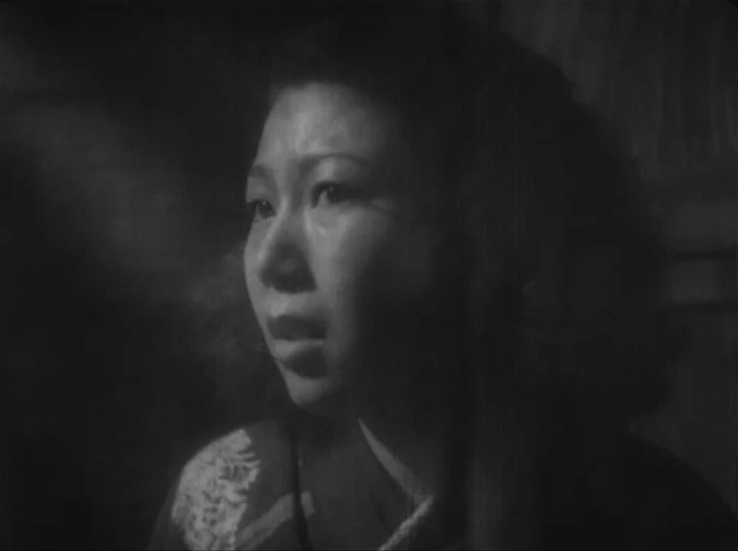 Drunken Angel (1948) movie still: closeup — A dimly lit room with the woman's face illuminated by a soft side light. She is looking off-screen with…