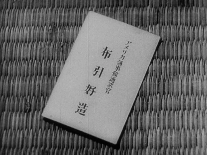Sanshiro Sugata Part II (1945) movie still: closeup — A rectangular paper document with Japanese text sits upon a woven tatami mat surface. The…