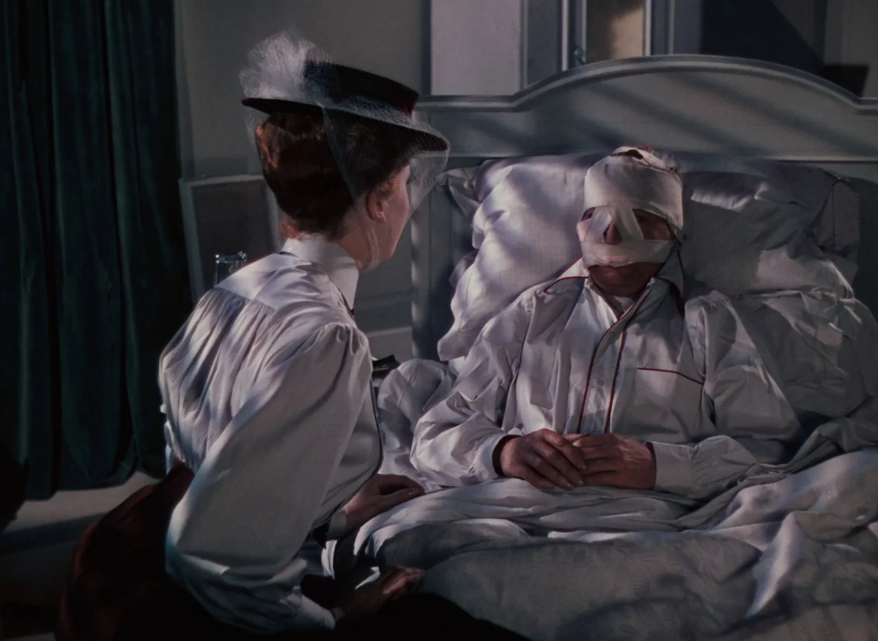 The Life and Death of Colonel Blimp (1943) movie still: medium — A dimly lit room features a hospital bed with a white headboard and pillows. A…