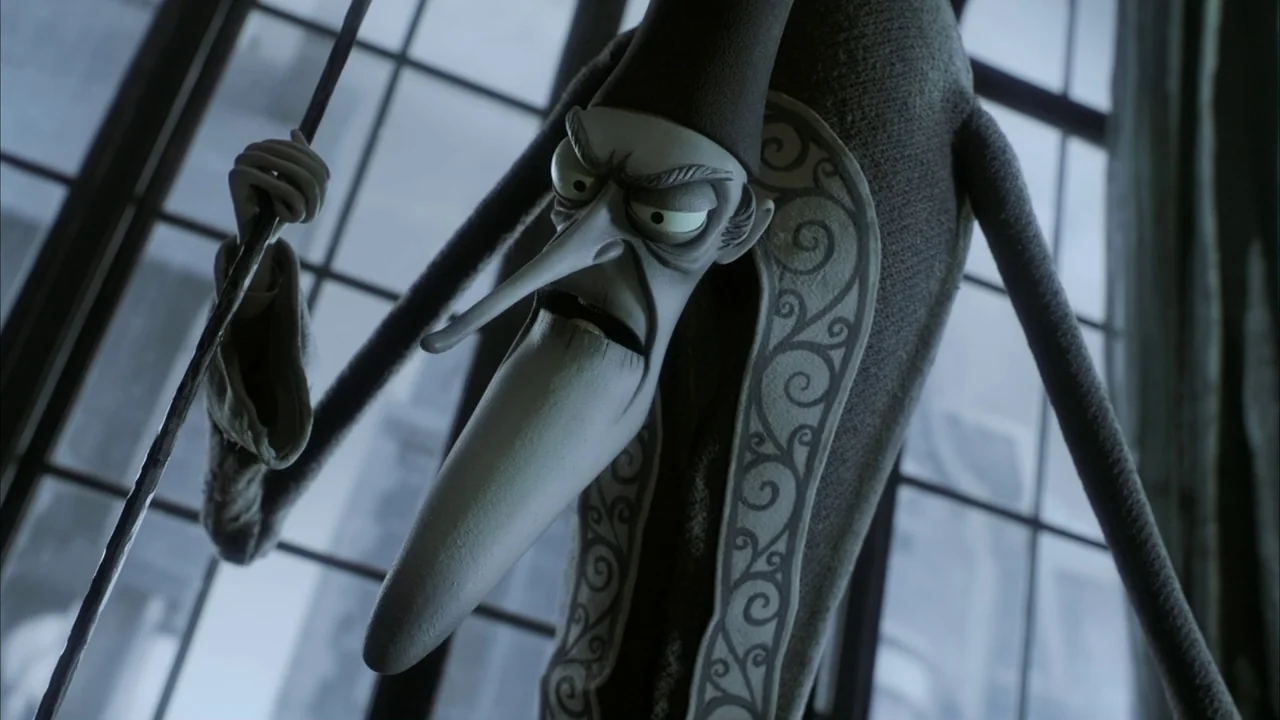 The Corpse Bride (2005) movie still: closeup — A tall, slender character stands against a large, grid-patterned window with gray light. The figure…