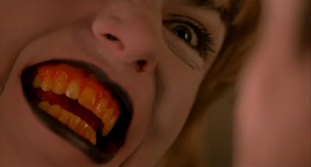 Twin Peaks: Fire Walk With Me (1992) movie still: closeup — A close-up view of a person with dark lips and stained teeth. The subject is looking…