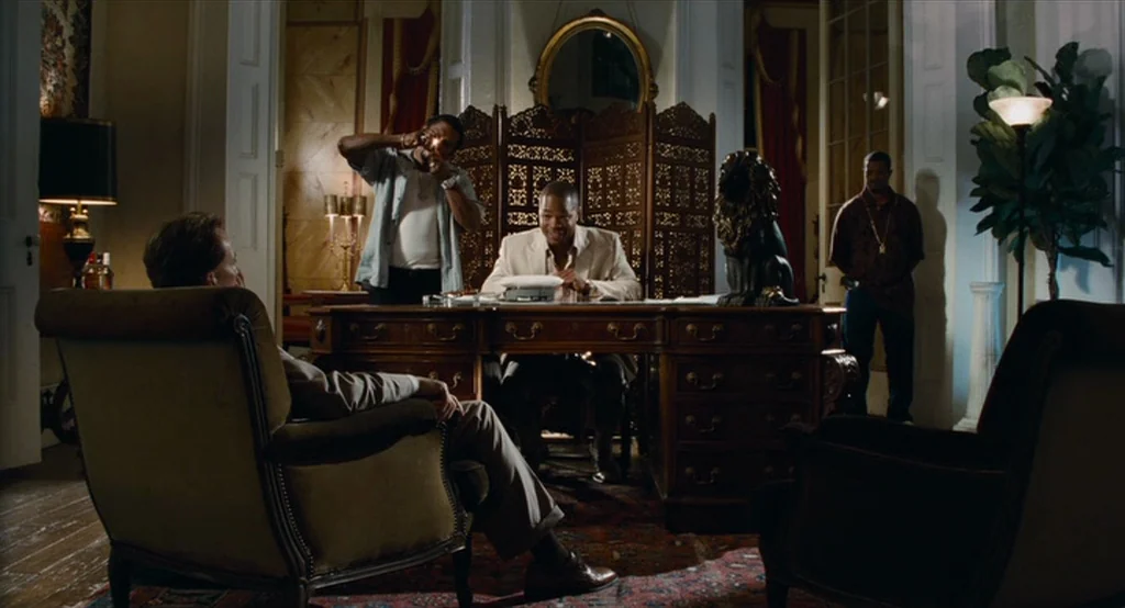 Bad Lieutenant: Port Of Call New Orleans (2009) movie still: wide — A formal wood-paneled room features a large desk with a central figure in a…