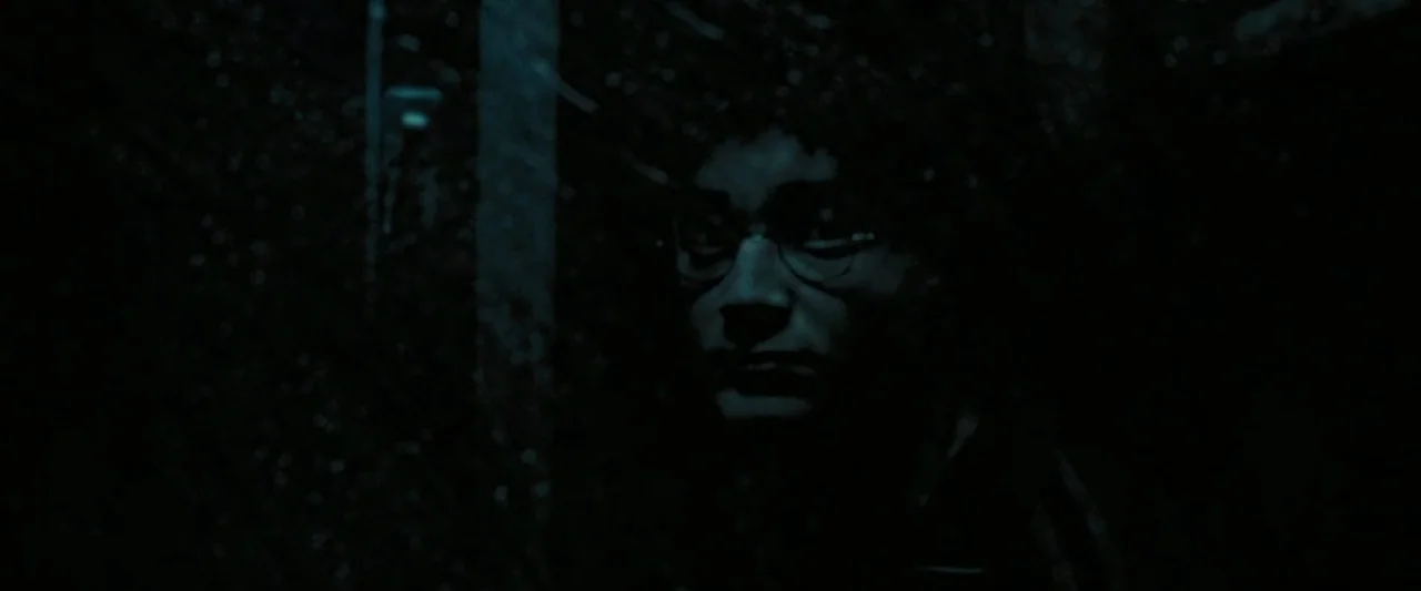 Harry Potter and the Prisoner of Azkaban (2004) movie still: closeup — A dark, dimly lit outdoor space obscured by heavy shadows and cool blue…