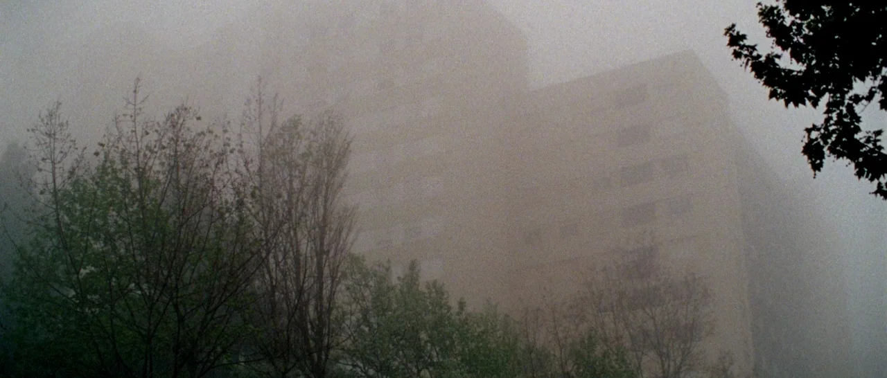Arabian Nights: Volume 2 The Desolate One (2015) movie still: establishing — A tall apartment building looms in the background behind several…