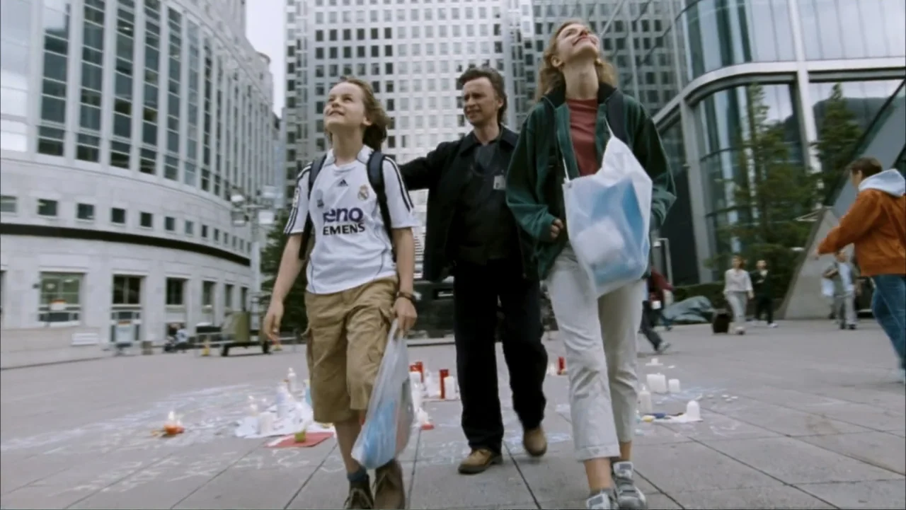 28 Weeks Later (2007) movie still: fullbody — A modern corporate office plaza with large glass-and-steel skyscrapers in the background. Three people…