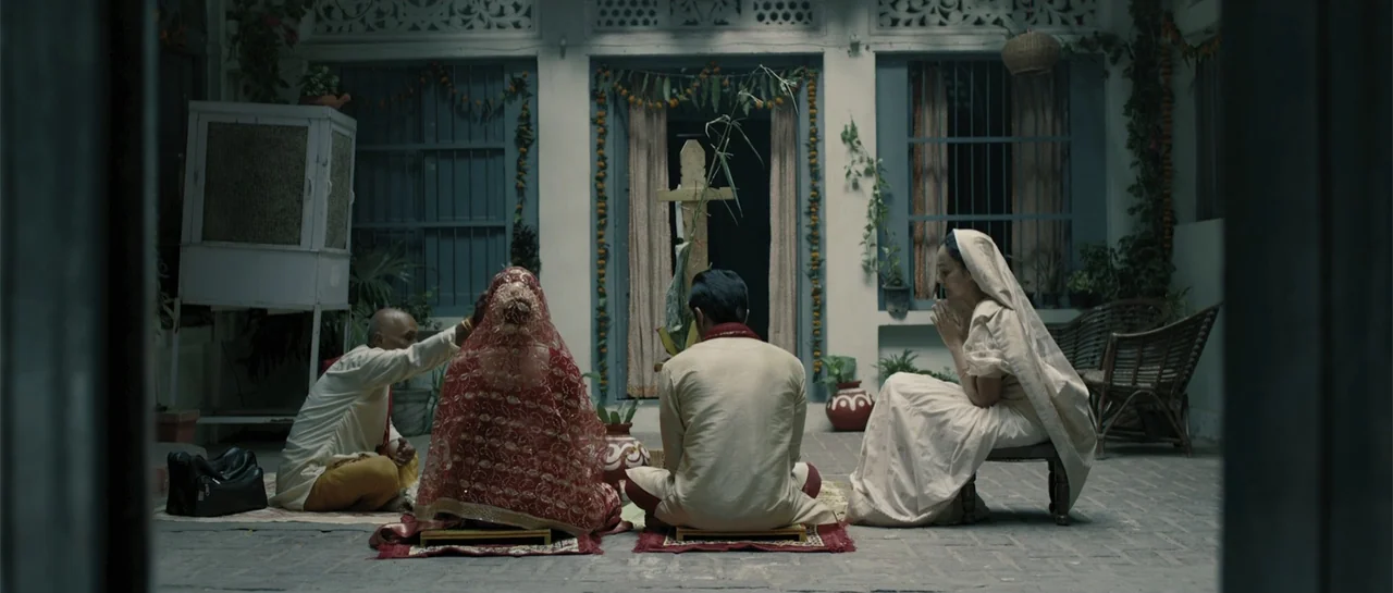 Nishaanchi 2 (2025) movie still: fullbody — A stone-paved central courtyard features arched doorways and rustic walls with festive floral garlands.…