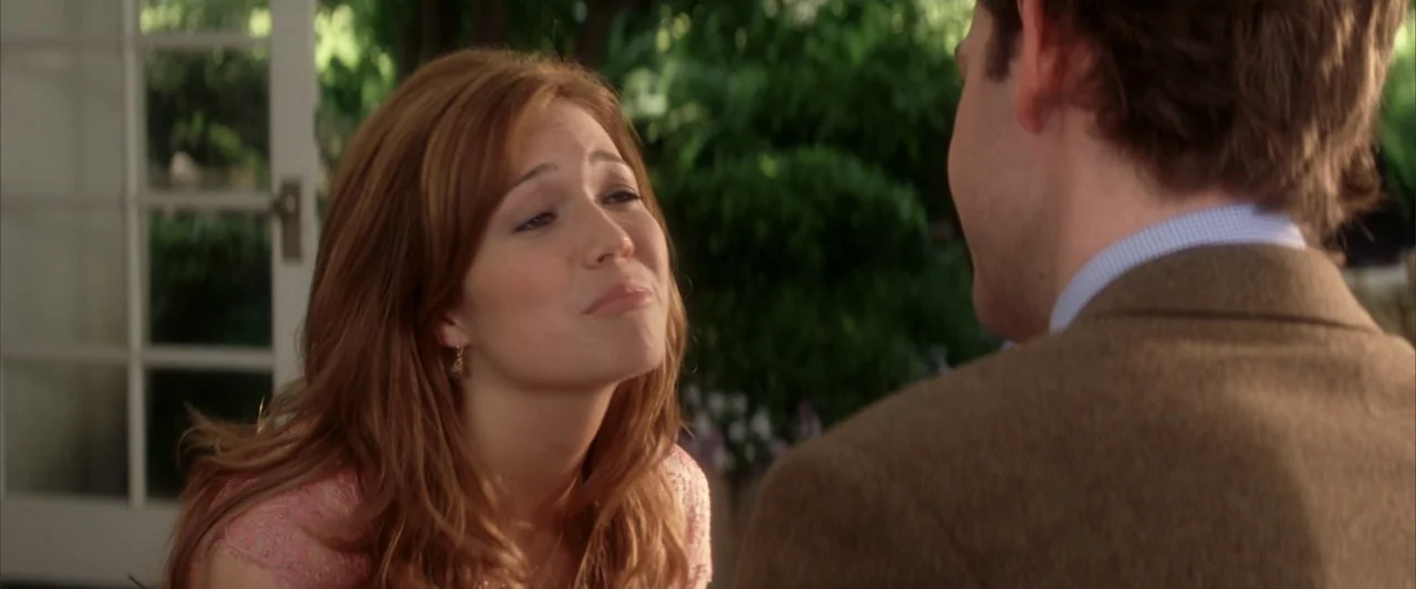 License to Wed (2007) movie still: medium — A sunlit patio features green foliage and a white window frame in the background. A woman in a pink lace…