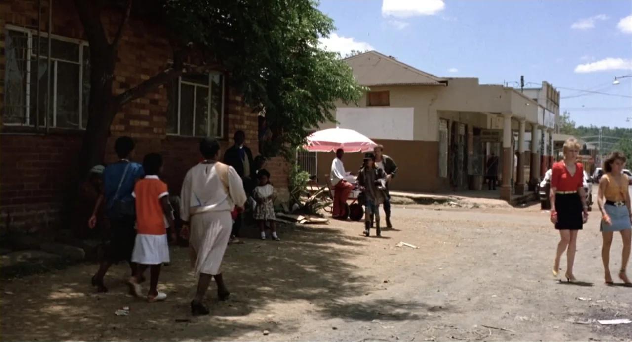 American Ninja 2: The Confrontation (1987) movie still: wide — A dusty dirt street in a small town features brick and stucco storefronts under…