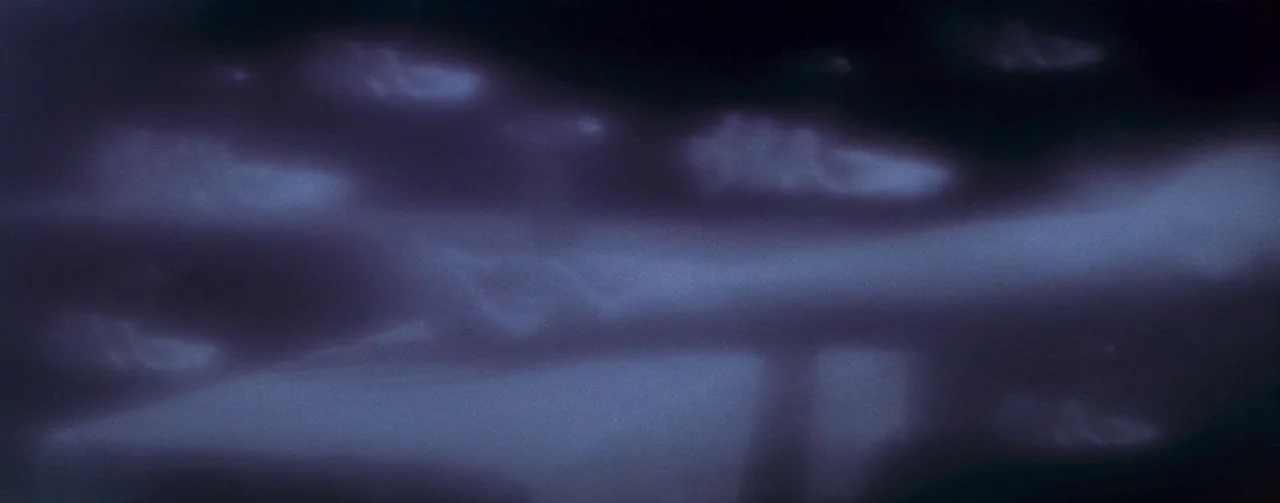 The Robe (1953) movie still: establishing — Wispy clouds drift slowly across a dark night sky. The scene shows the night atmosphere with soft blue…