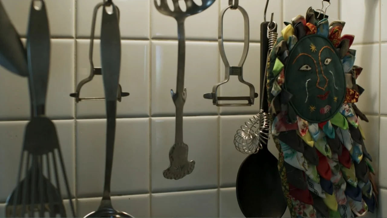 Victoria's Secret: The Tour '23 (2023) movie still: closeup — A wall covered in white square tiles features metal utensils hanging from hooks. A…