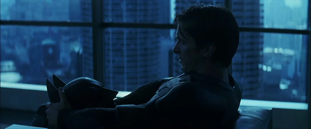 The Dark Knight (2008) movie still: medium — A high-rise modern apartment overlooks a dark city with illuminated skyscraper windows at night. A man…