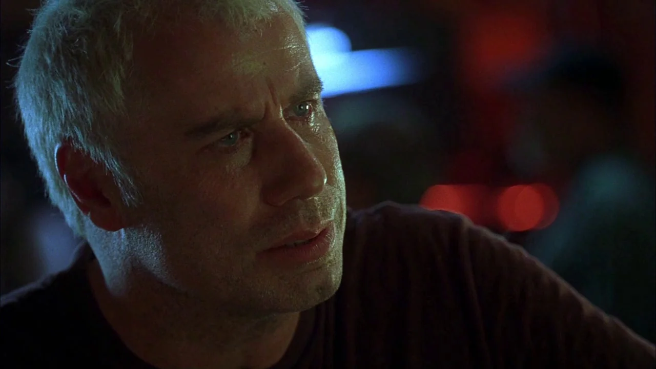 Love Song For Bobby Long (2004) movie still: closeup — A dark, dimly lit bar environment with blurred light sources in the background. A middle-aged…