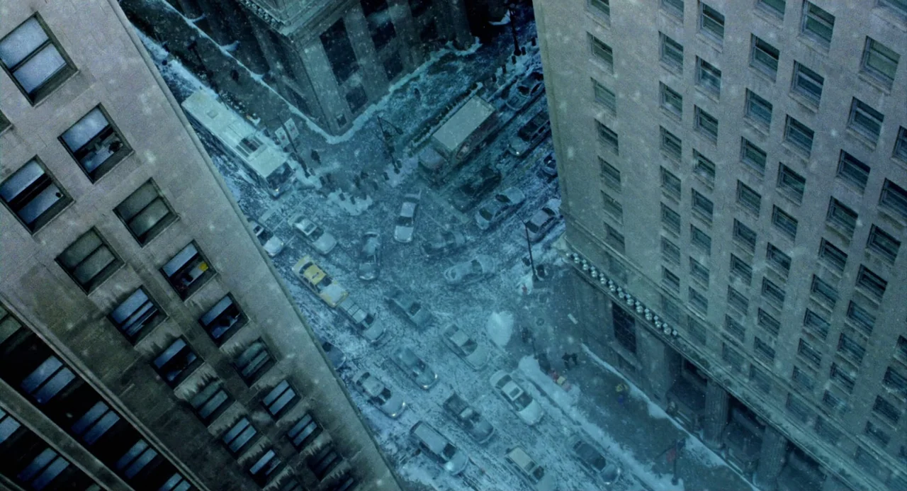 The Weather Man (2005) movie still: establishing — A high-angle view looks down at a busy intersection covered in light snow. Several cars and a bus…