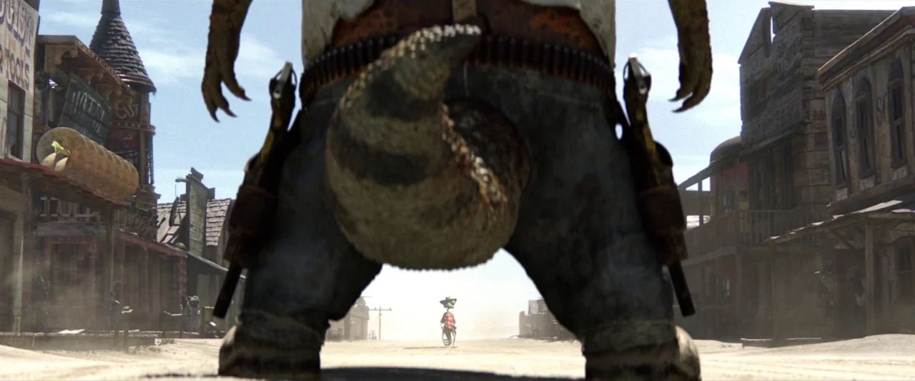 Rango (2011) movie still: fullbody — A dusty, sun-bleached main street in a classic western settlement with wooden storefronts. A large reptilian…