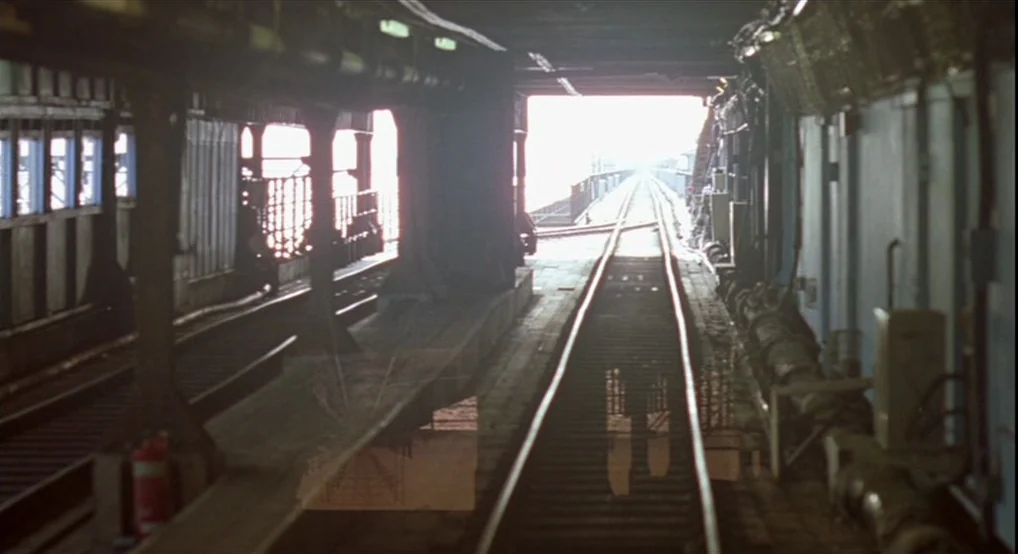 Breakfast On Pluto (2005) movie still: establishing — An industrial subway terminal features rusted metal pillars and parallel railway tracks…