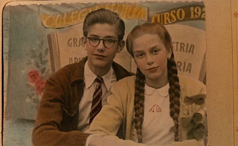 Spirit Of The Beehive (1973) movie still: medium — Two teenagers pose for a formal school photograph in front of a painted backdrop. The backdrop…