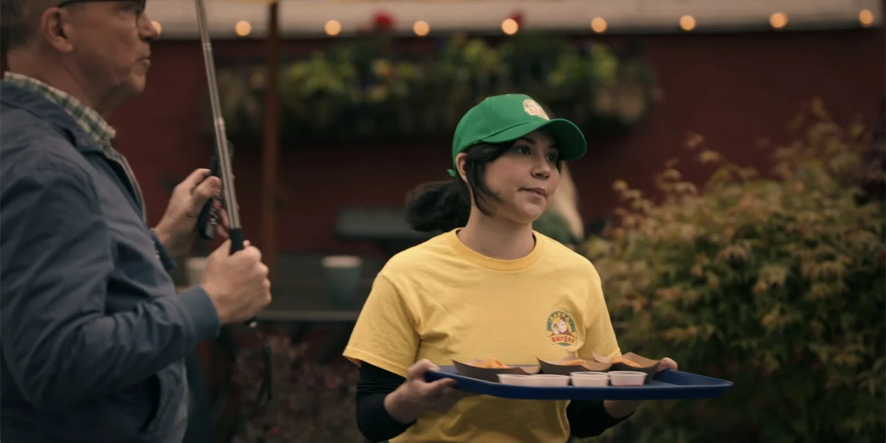 Totally Killer (2023) movie still: medium — An outdoor restaurant patio at twilight with string lights visible in the blurred background. A young…