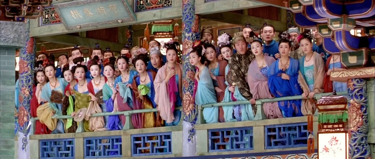 House of Flying Daggers (2004) movie still: wide — A crowded wooden balcony in a traditional Chinese building features ornate columns and carvings.…