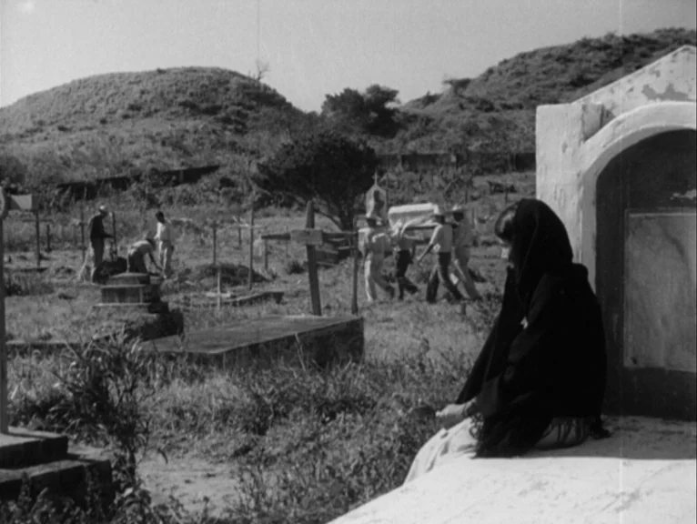 Redes (1936) movie still: wide — An open rural cemetery features scattered stone markers and dry, overgrown grass. Men in light shirts and hats…