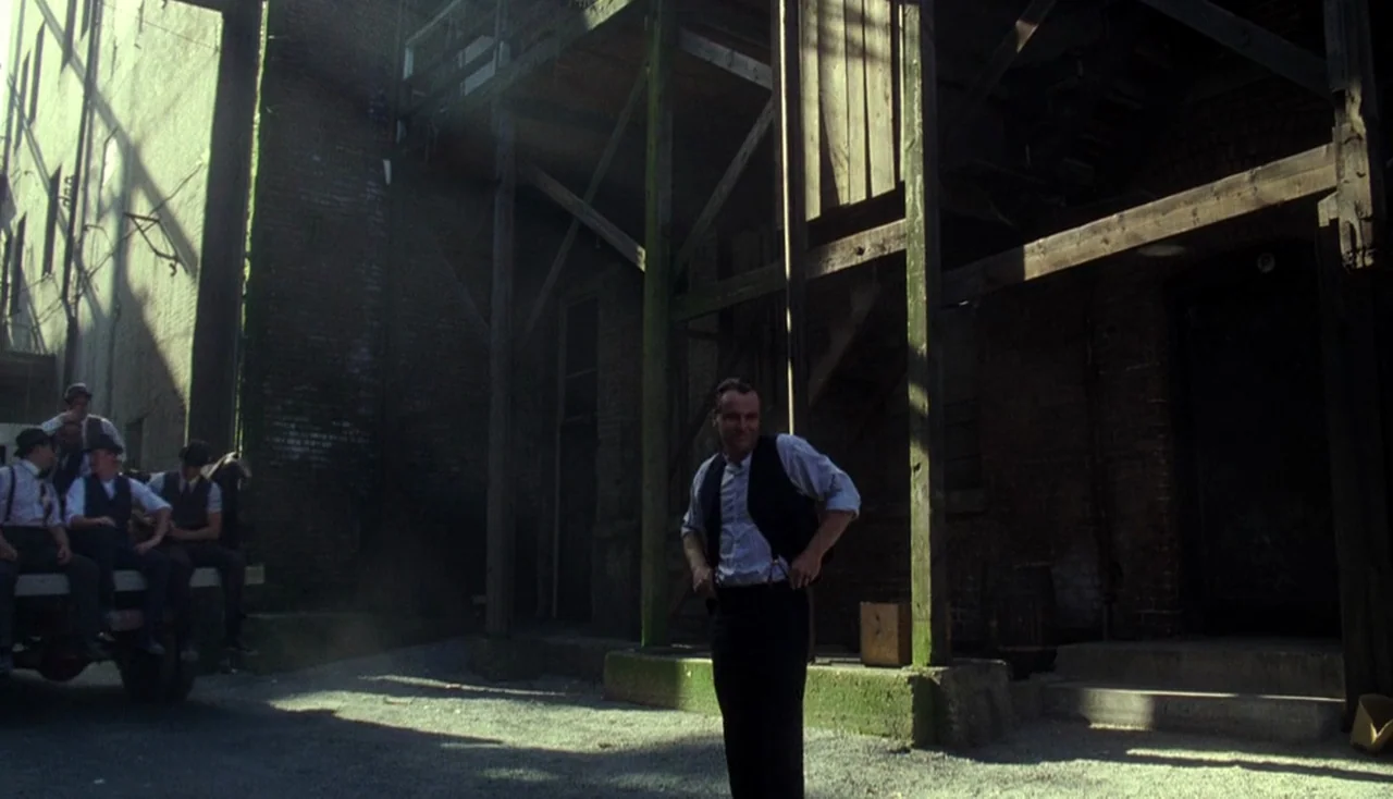 Legends of the Fall (1994) movie still: fullbody — A gritty industrial loading area features dark brick walls and wooden structural supports.…
