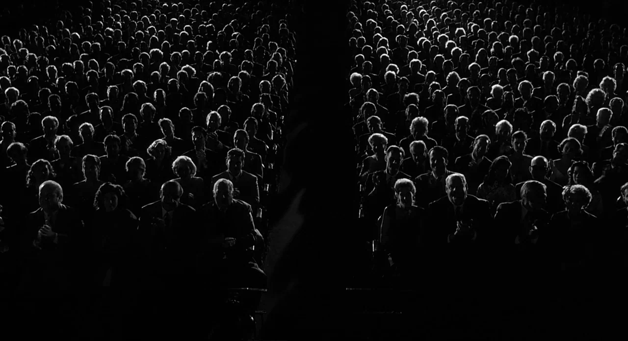 Ed Wood (1994) movie still: wide — A large theater auditorium is filled with a dense crowd of seated people. The audience faces forward in the dark…