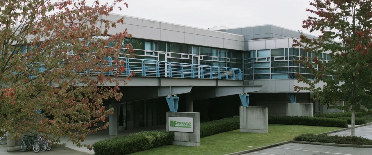 Final Destination 5 (2011) movie still: establishing — A modern two-story office building features metal siding and glass curtain wall panels. A…