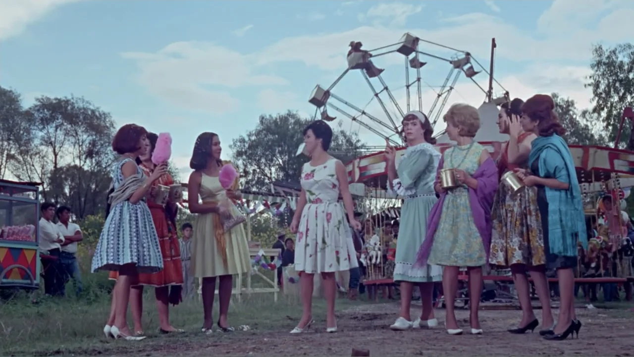 Los Dos Rivales (1966) movie still: wide — A sunlit carnival ground features a Ferris wheel and merry-go-round in the background. Several women…