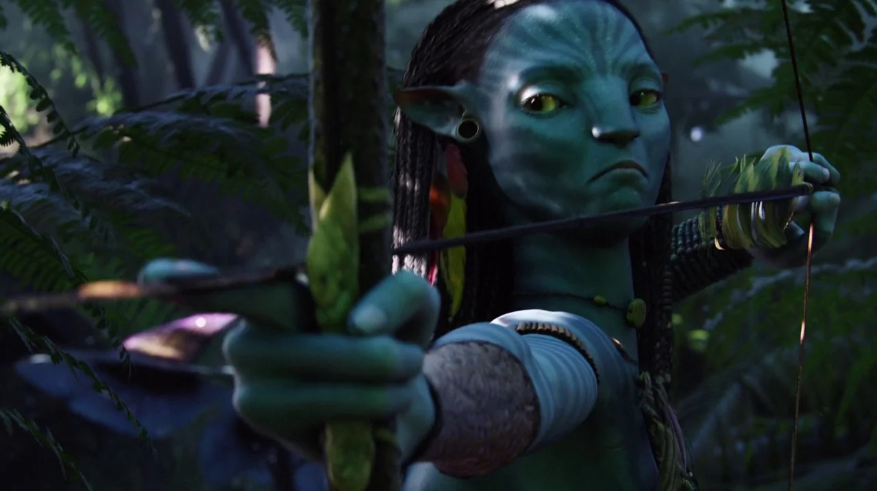 Avatar (2009) movie still: closeup — A dense, lush jungle environment with thick foliage and filtered sunlight. A blue-skinned humanoid character…