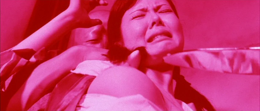 The Horrors of Malformed Men (1969) movie still: closeup — A close-up view shows a woman with eyes closed under duress in a dark room. Another…