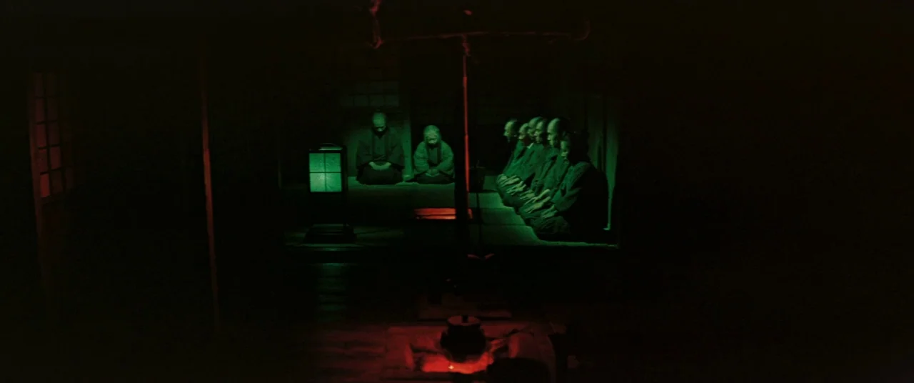 Ballad Of Narayama (1958) movie still: wide — A dark, dimly lit Japanese interior with tatami mats and wooden structural elements. A group of men in…