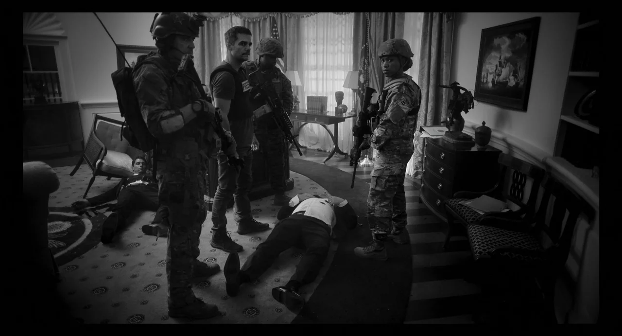 Civil War (2024) movie still: wide — An opulent room with patterned carpet and window curtains resembling an executive office setting. Two bodies in…