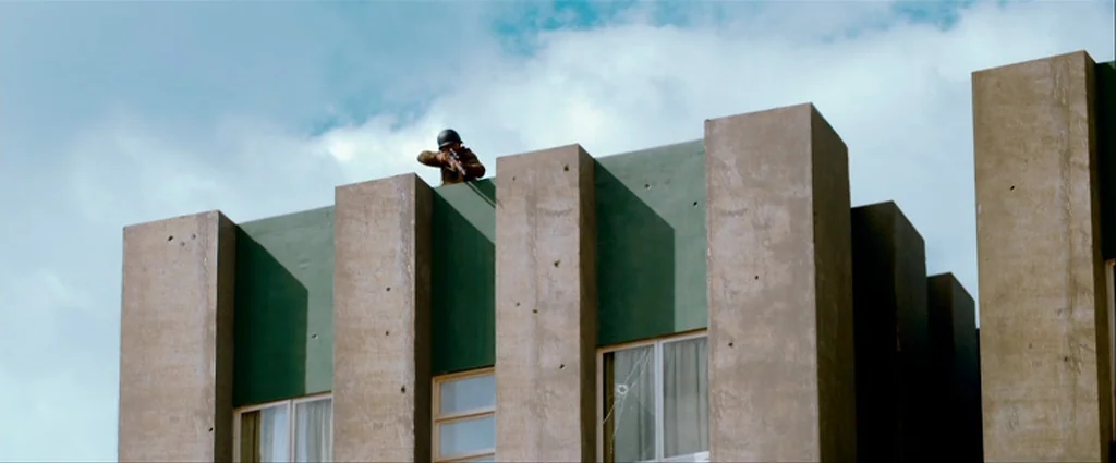 Che Part 1 (The Argentine) (2008) movie still: wide — A modernist building facade with tall vertical concrete pillars and green wall segments. A…