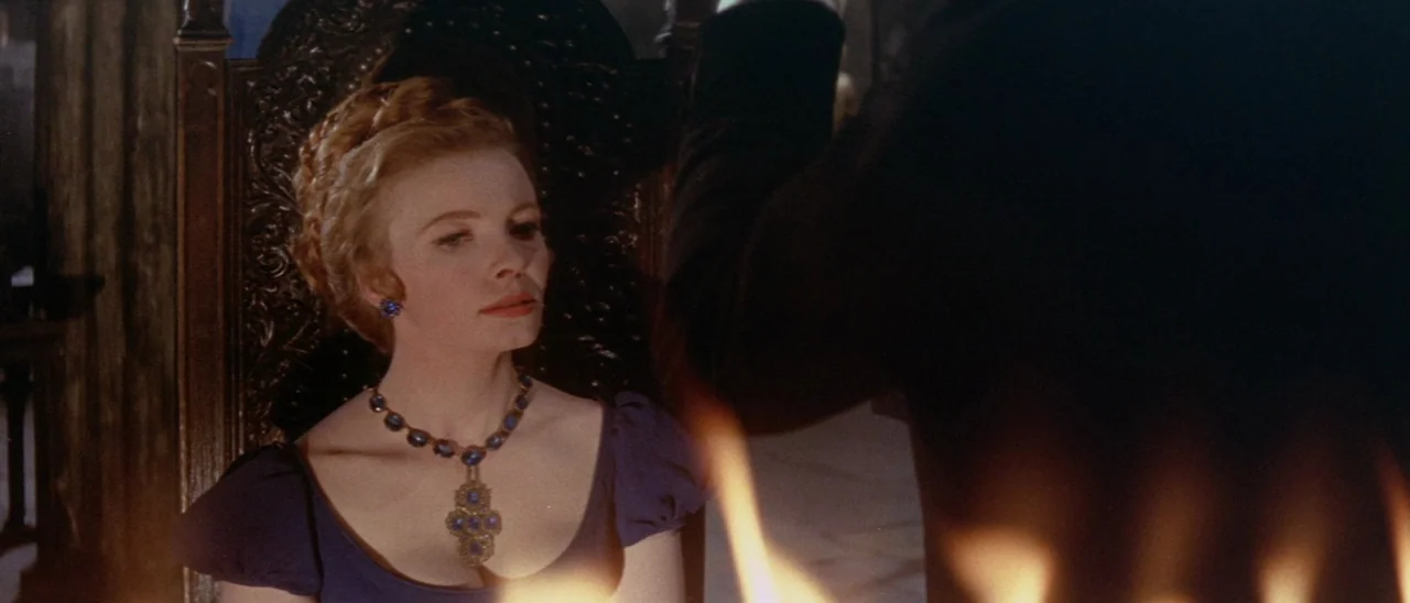 The Tomb of Ligeia (1964) movie still: medium — A dark stone interior features a woman seated in a heavily carved wooden throne. Warm firelight…