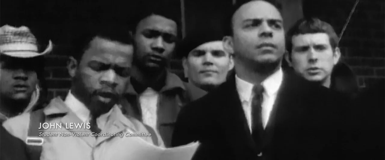 All In: The Fight for Democracy (2020) movie still: medium — A group of young men stand in front of a dark brick wall exterior. John Lewis is in the…