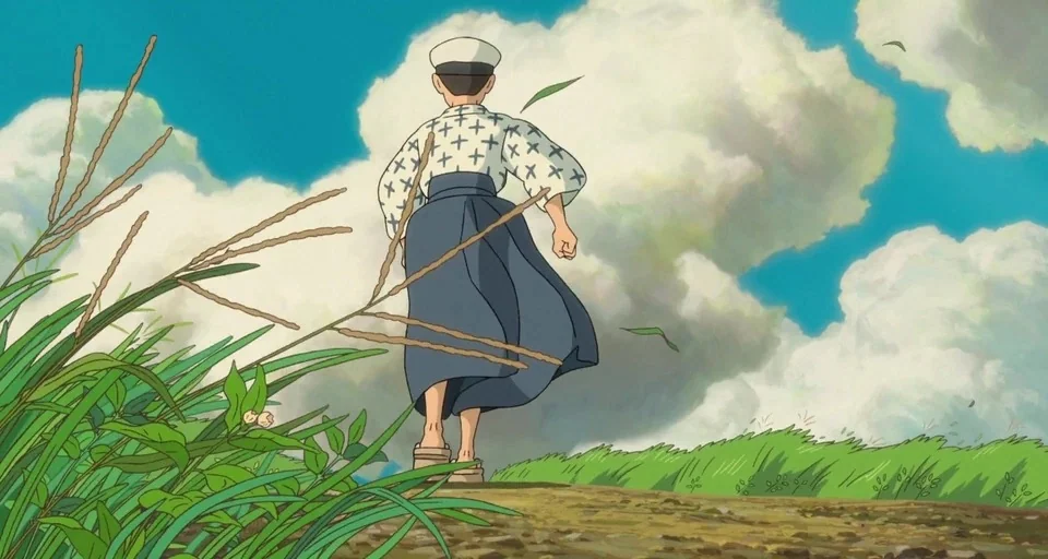 The Wind Rises (2013) movie still: fullbody — A rural landscape features a dirt path flanked by tall green grass and weeds. A young boy walks away…
