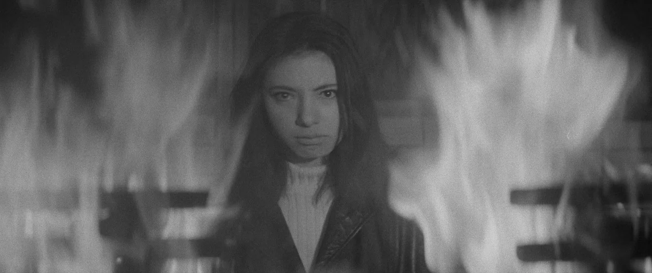 Carmen From Kawachi (1966) movie still: medium — A woman stands behind a burning fire that obscures parts of the mid-frame. Large flames erupt in…