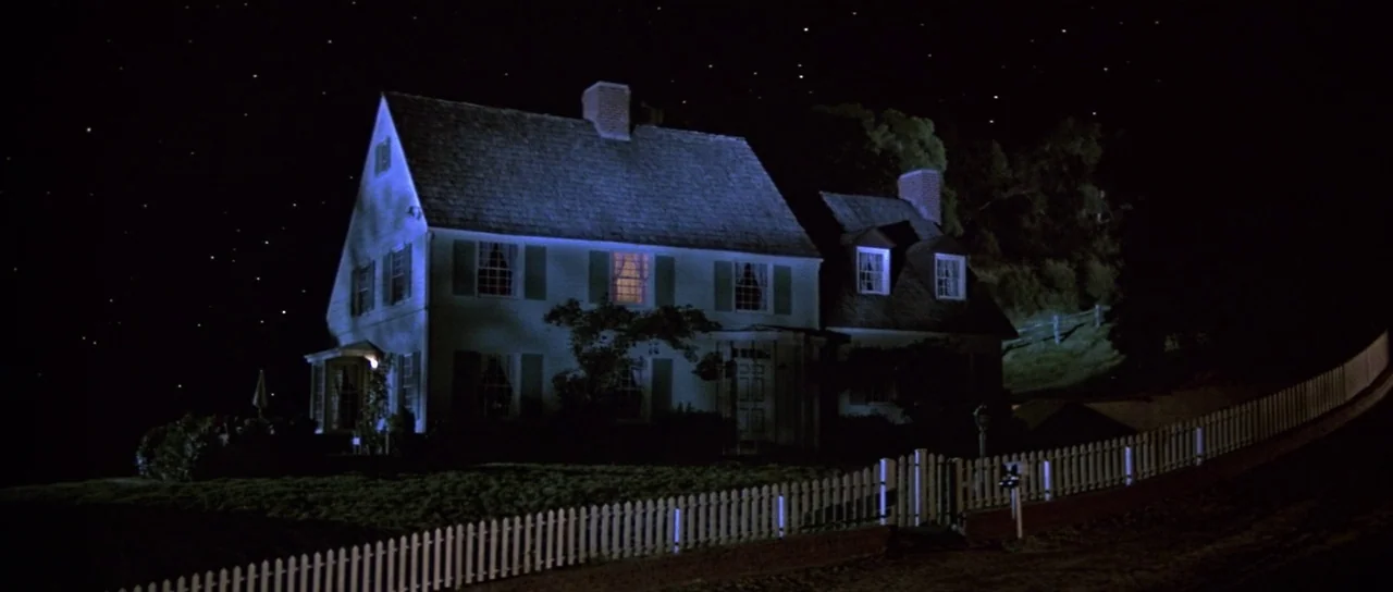 Invaders From Mars (1986) movie still: establishing — A two-story suburban home with a white picket fence stands under a starry night. The house…