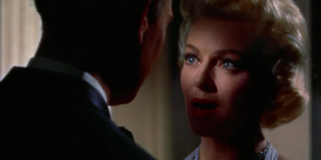 Imitation of Life (1959) movie still: closeup — An indoor setting with dim lighting creates a focused, high-contrast environment. A woman with…