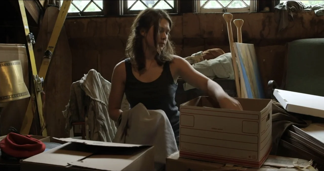Faith, Love & Chocolate (2018) movie still: medium — A cluttered attic filled with cardboard boxes and various stored household items near windows.…