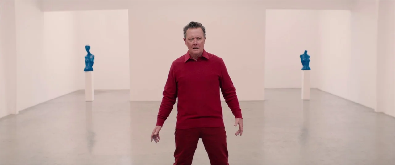 Tone Deaf (2019) movie still: fullbody — A spacious, minimalist art gallery with white walls and a smooth polished concrete floor. An older man…