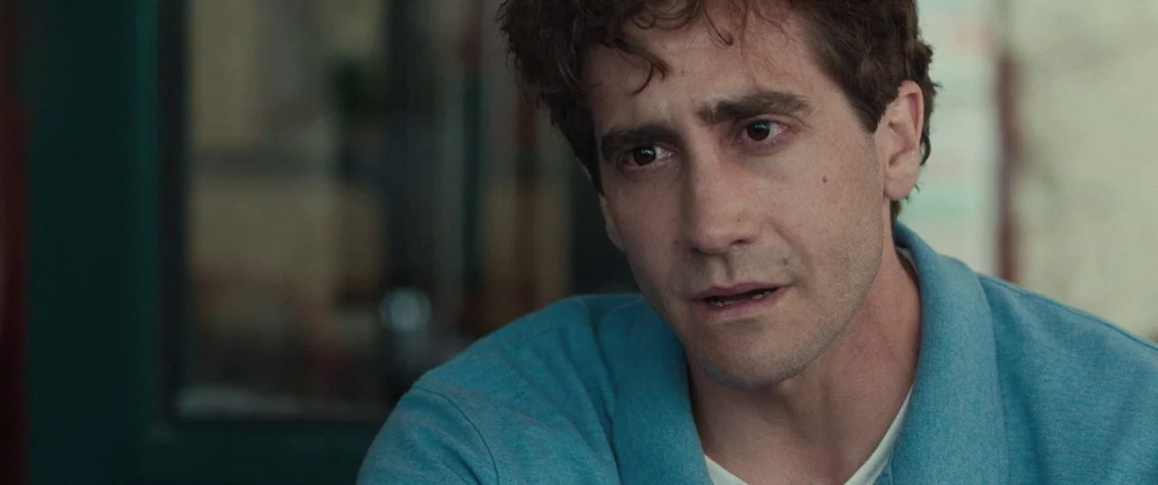 Stronger (2017) movie still: closeup — A man sits indoors in a brightly lit, nondescript room. He looks slightly off-camera with his mouth open as…