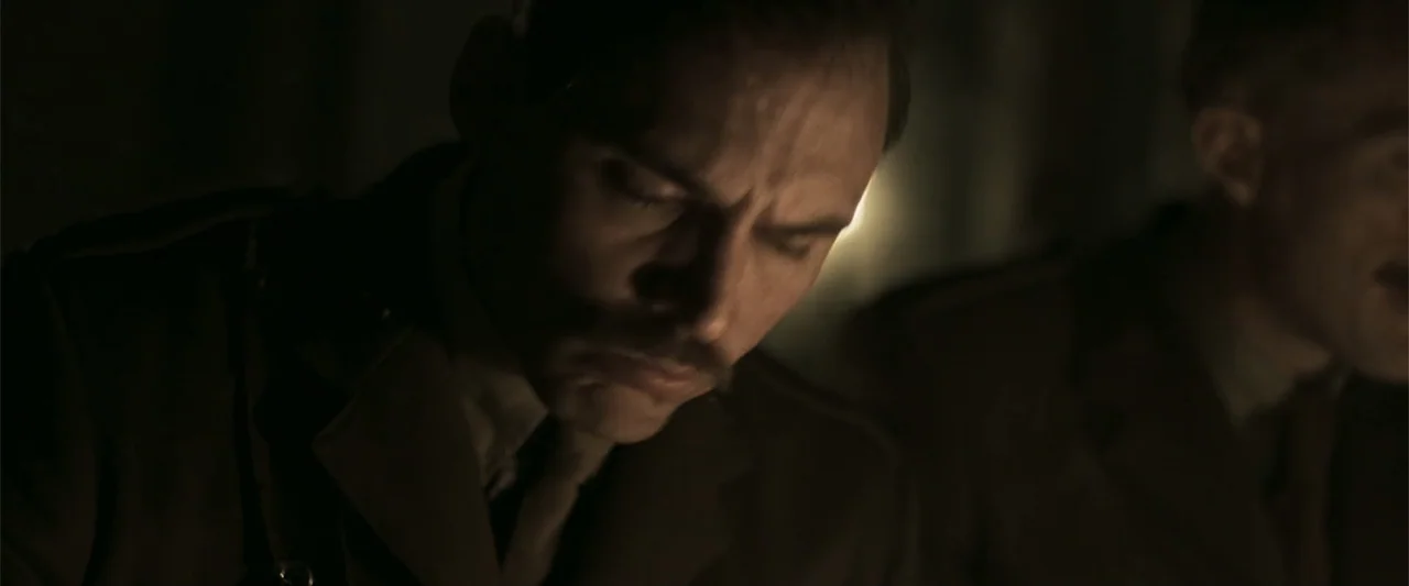 Gone Missing -  Old John's Final Journey (2014) movie still: closeup — A dark military interior contains two men in uniforms. They sit together in…