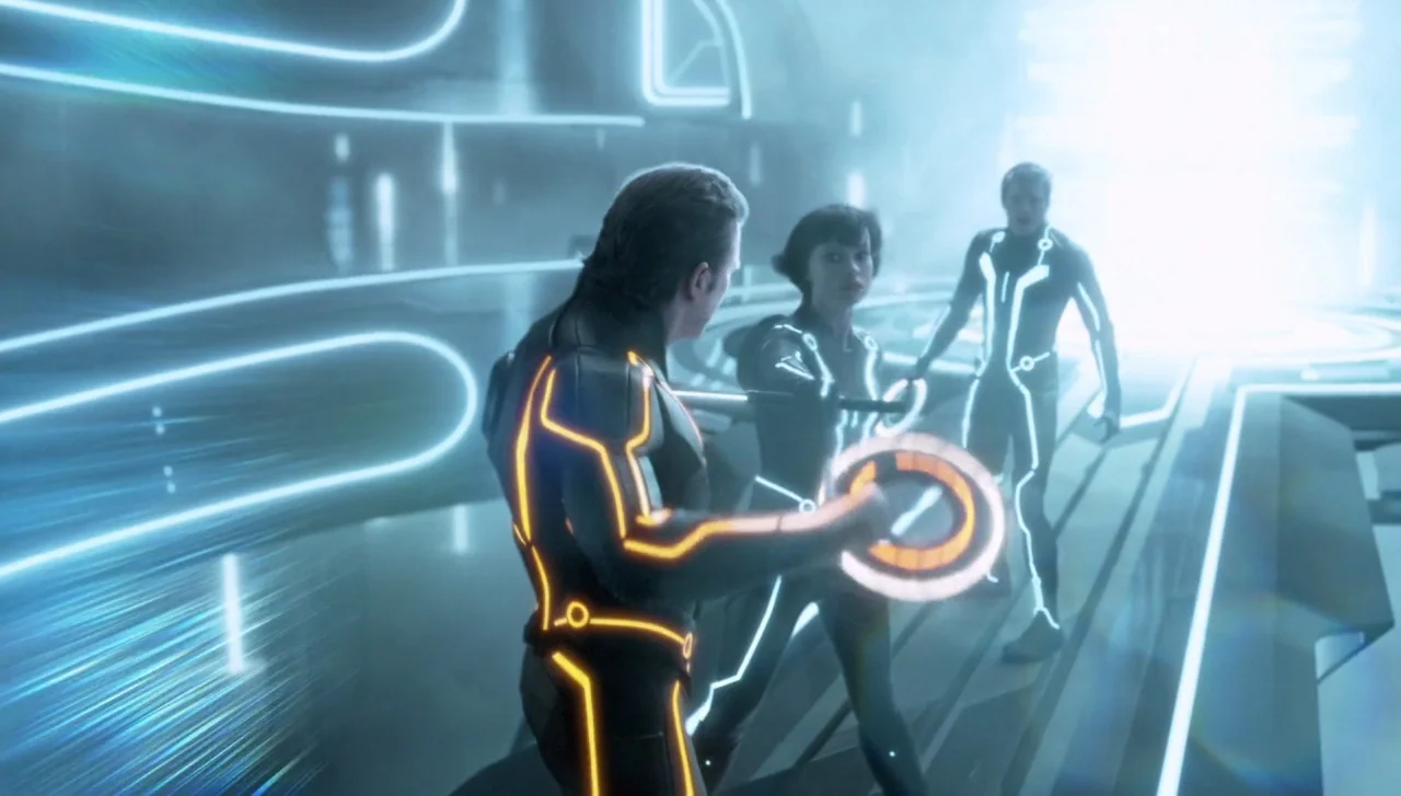 TRON: Legacy (2010) movie still: medium — A sleek digital corridor features glowing white surfaces and abstract neon architectural lines. A man in…